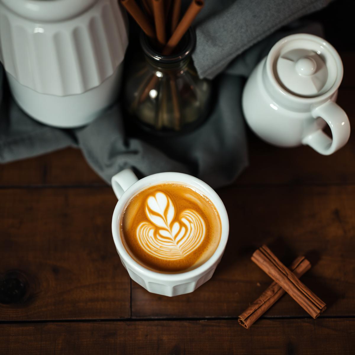 Tres leches latte with delicate latte art and cinnamon sticks